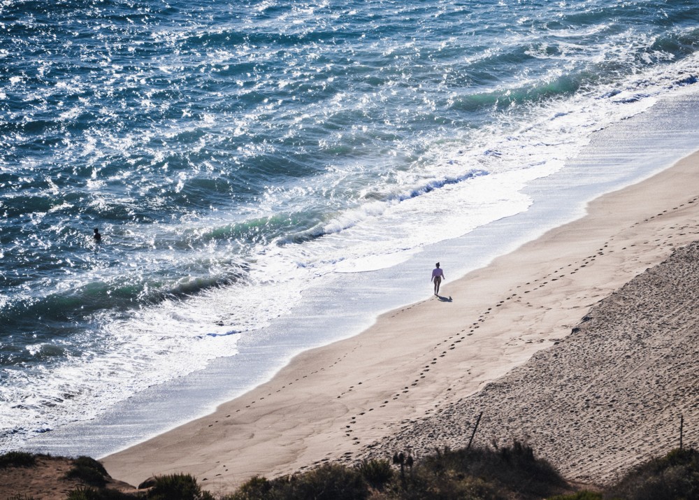 A solitary figure beside waves on the coast