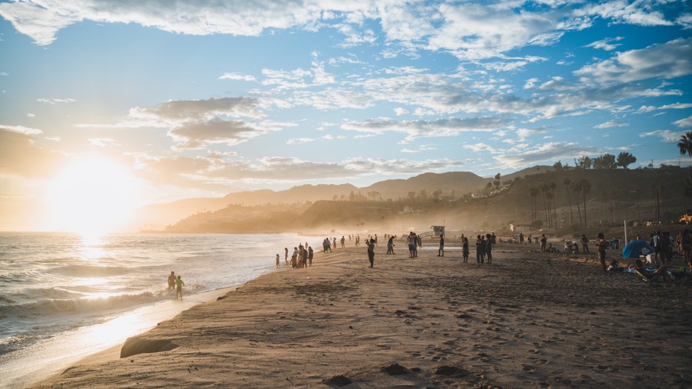 Golden sunset over a beach with distant mountains